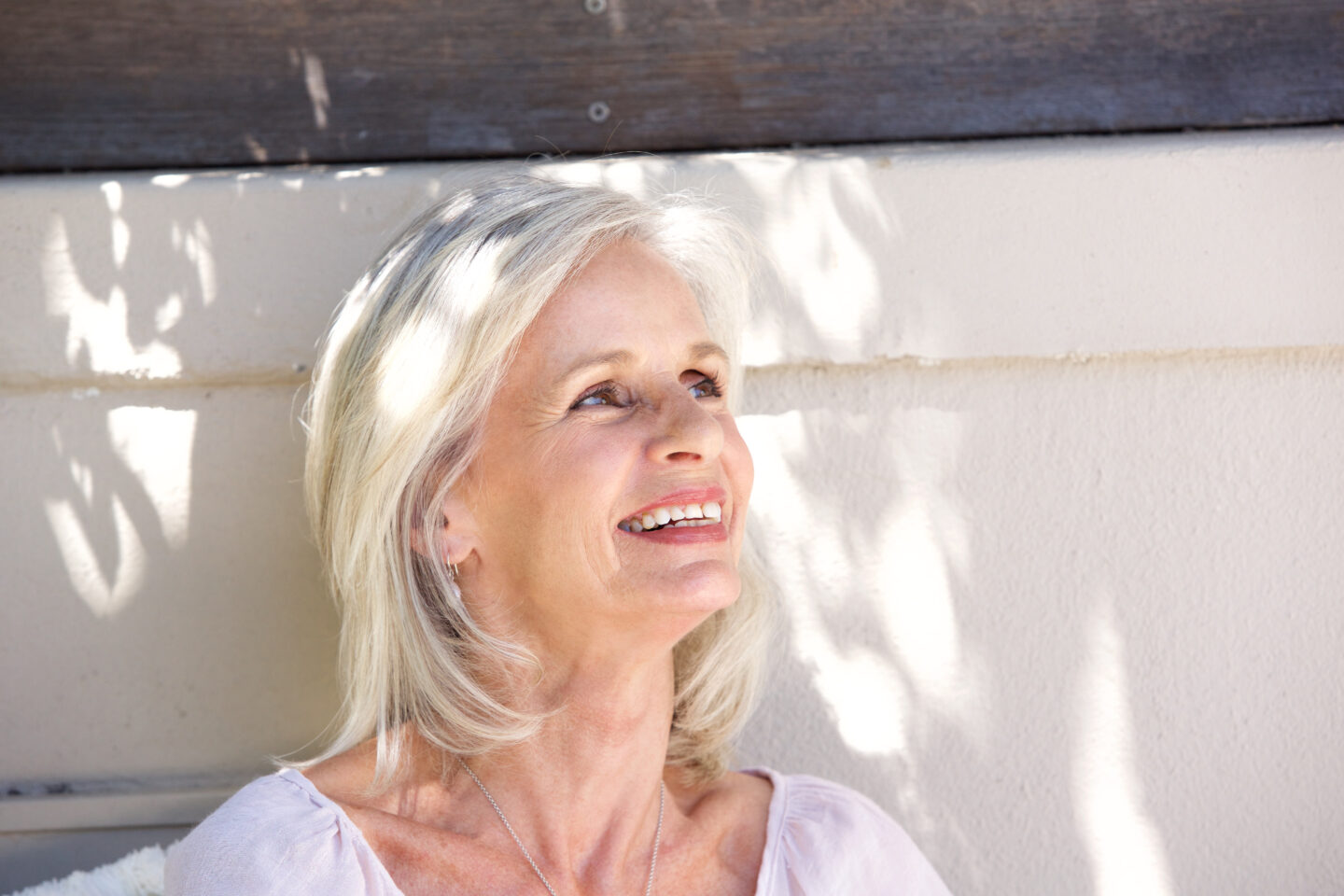 Smiling older adult enjoying time outdoors, a natural portrait for shingles vaccination information