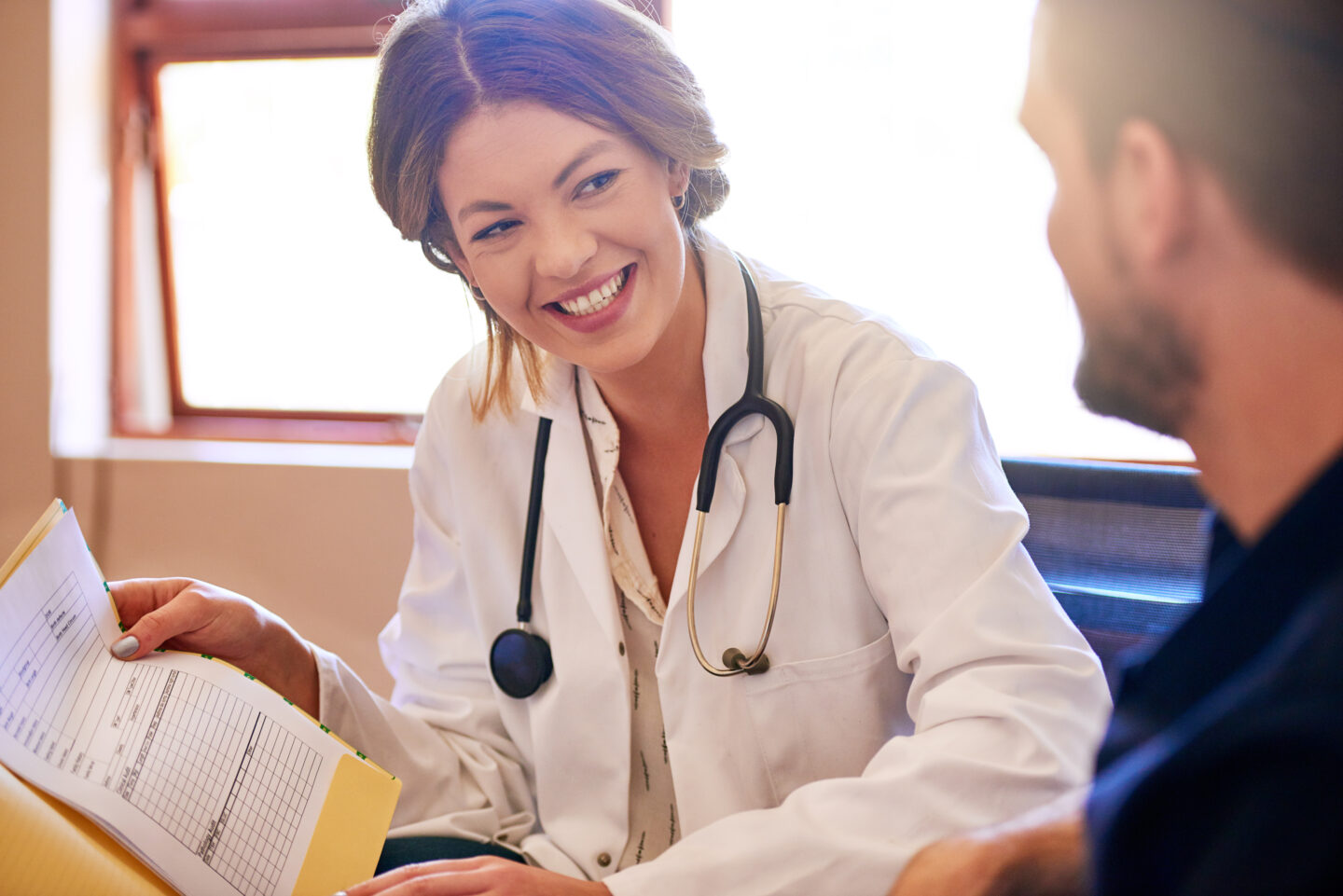Doctor consulting with an adult patient in a travel health clinic ahead of a hepatitis B vaccination