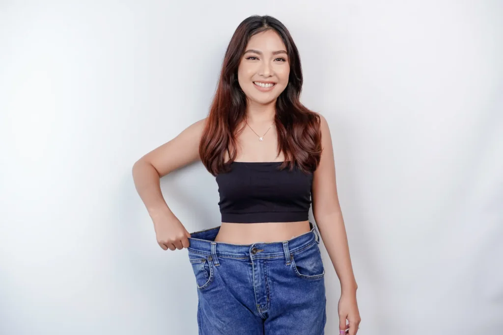 A woman in jeans showing off more room after losing weight
